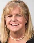 portrait of mary burns in a black top wearing white pearls