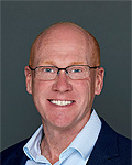 portrait of jim mcgaugh in a dark suit and light blue shirt