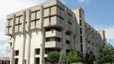 olsen hall at umass lowell - cement multi level structure with greenery of varying sizes in front